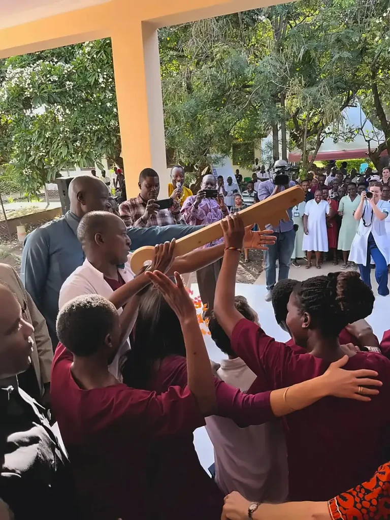 A group of people at the Shirati Opening with a wooden key and an audience